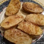 Gluten-Free Pan-Baked Potatoes Cooked in the Microwave. Six halves on a decorative plate.