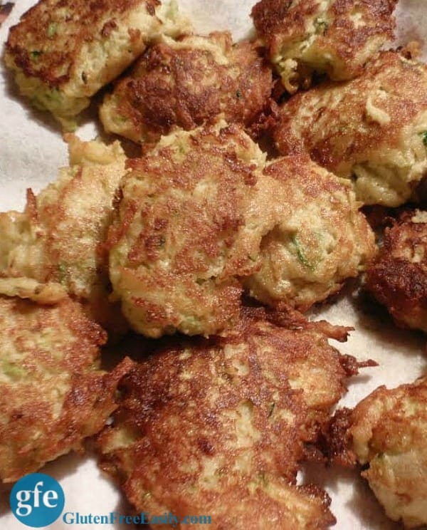 Gluten-Free Zucchini Fritters on a paper towel-lined plate. These melt in your mouth!