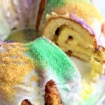Gluten-Free King Cake from She Let Them Eat Gluten-Free Cake with slice removed on white cake platter.