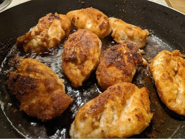 Perfect Gluten-Free Fried Chicken Breasts frying in the skillet.