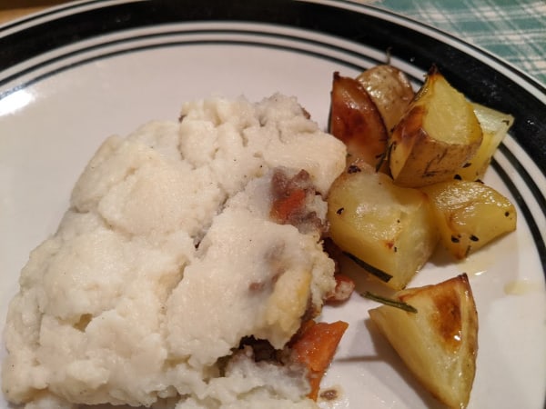 A serving of Gluten-Free Shepherd's Pie with Whipped Cauliflower Topping and Rosemary Potatoes