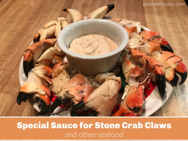 Special sauce for dipping stone crab claws in a ramekin surrounded by cracked stone crab claws.