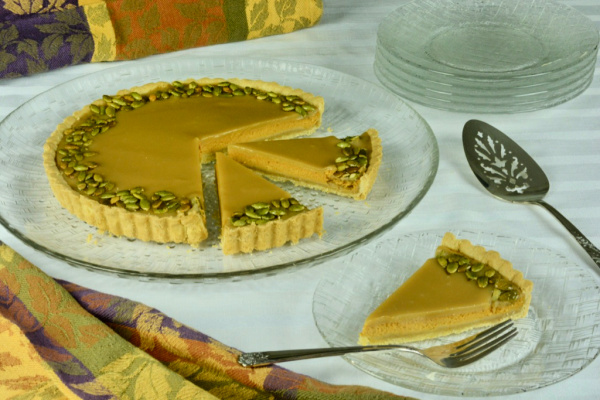 Gluten-Free Bourbon Caramel Pumpkin Tart with one slice on plate and two slices on platter with pie.