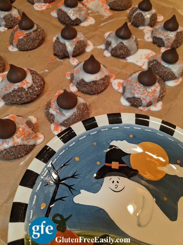 Gluten-Free Witch Hat Cookies on brown paper next to Halloween ghost plate.