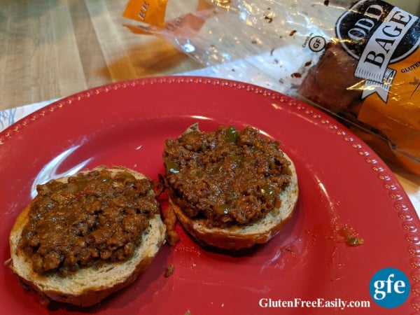 Quick and Easy Gluten-Free Sloppy Joes open faced on onion Odd Bagel, with open bag of Odd Bagels.
