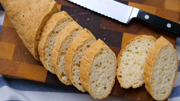 Gluten-Free Baguette from No Gluten, No Problem. Sliced on checkerboard cutting board. One of the gluten-free French bread and baguette recipes featured on gfe.