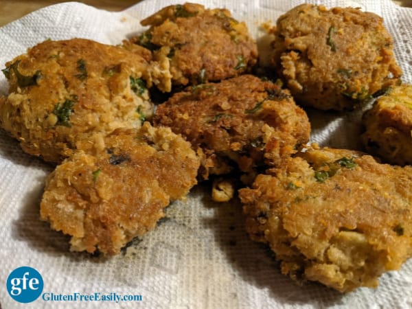 Gluten-Free Quinoa-Crusted Salmon Cake draining on paper towel-lined plate.