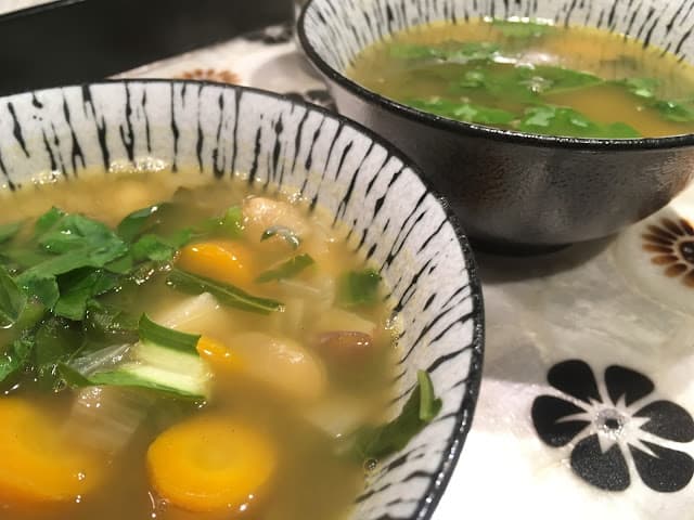 Two bowls of Kale and Cannellini White Bean Soup. One of the gluten-free Purim recipes featured on gfe.