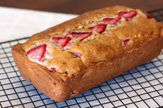 Gluten-free and vegan Strawberry Banana Bread from Sarah Bakes Gluten Free cooling on wire rack on marble counter. One of the best gluten-free banana bread recipes featured on gfe.