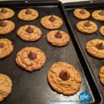 Flourless Gluten-Free Peanut Butter Blossom Cookies setting up on baking sheets.
