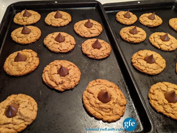 Flourless Gluten-Free Peanut Butter Blossom Cookies setting up on baking sheets.