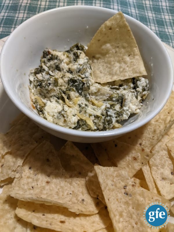 Gluten-Free Hot Spinach Artichoke Dip on Table Ready to Eat on Plate with Tortilla Chips.