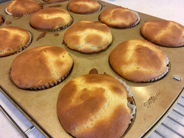 Gluten-Free Light and Fluffy Orange Muffins with Orange Glaze cooling slightly in muffin pan on rack before adding glaze.