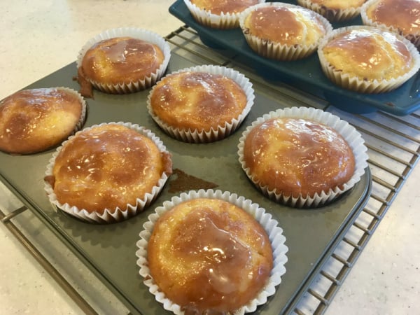 Gluten-Free Light and Fluffy Orange Muffins with Orange Glaze (and Poppy Seed Option) cooling in muffin pan on rack. From Successfully Gluten Free.