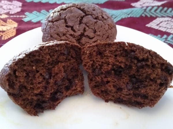 Gluten-Free Coconut Chocolate Mint Muffins (Paleo) from Gluten-Free & Paleo Travels. Two on a white plate with close-up of one split in half.