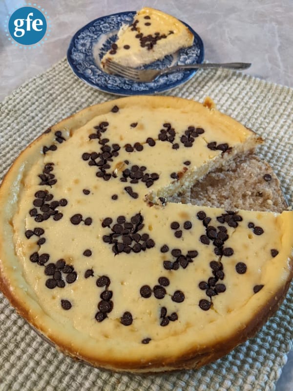 https://glutenfreeeasily.com/wp-content/uploads/2023/05/Gluten-Free-Crustless-Cheesecake-Flourless-with-Slice-Removed-and-On-Plate-Photo-1.jpg