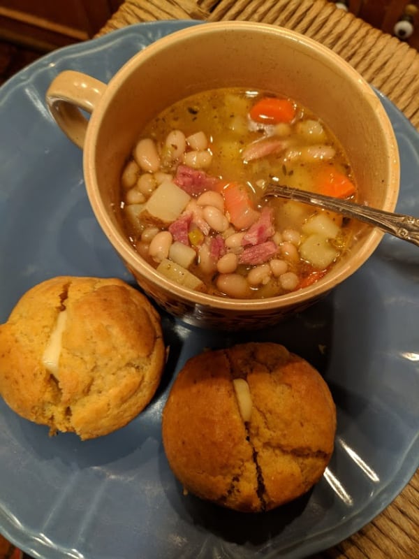 Gluten-Free White Bean and Ham Soup in a soup mug with two gluten-free almond dinner rolls.