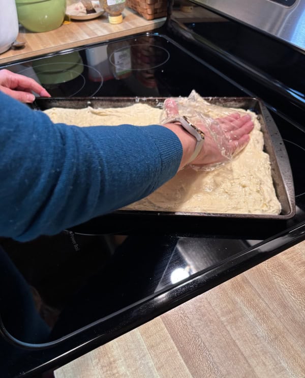 Linda smoothing out the Gluten-Free Focaccia dough using her baggie trick.