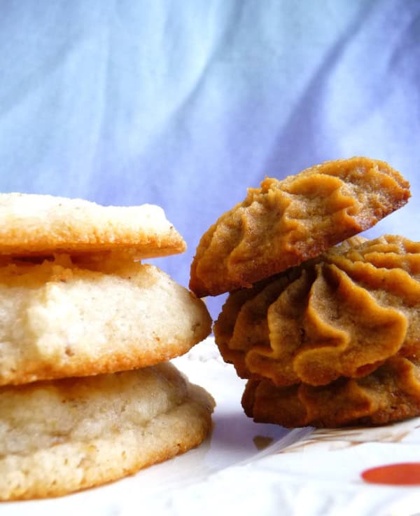 Gluten-Free Cream Cheese Cookies. Not just gluten free but also dairy free, egg free, and vegan. Shown as drop cookies made with granulated white sugar on the left and a stack of piped cookies made with coconut/palm sugar on the right.