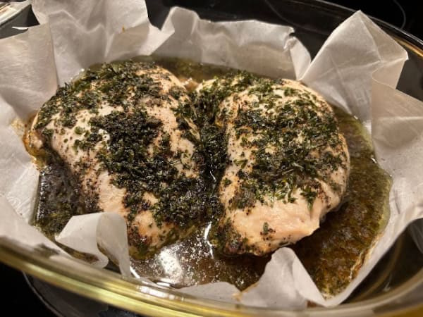 Gluten-Free Zesty Turkey Breast Tenderloins resting in parchment-lined baking dish after baking and before slicing. This was one of my early test runs, which ended up resulted in too much of a vinegar taste.