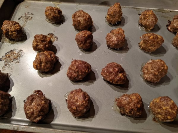 Easy Gluten-Free Italian Meatballs after baking with most still on the baking sheet. Except for a few missing "test" sampled meatballs.