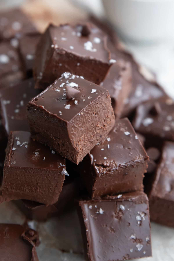 Creamy Keto Fudge stacked on a plate. Part of a collection of the best gluten-free fudge recipes. Recipes worth gifting for the holidays and beyond!