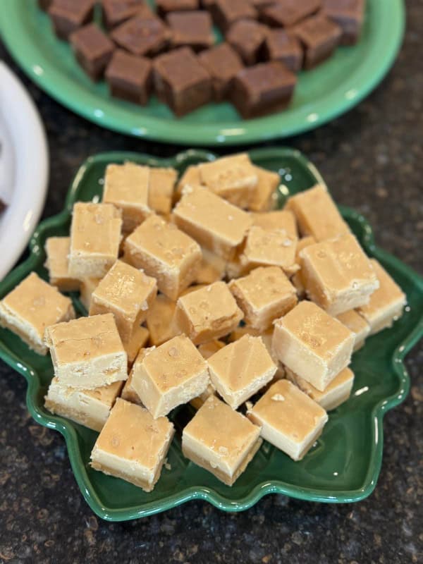 Salted Caramel Fudge stacked in a green holiday plate next to Peanut Butter Chocolate Fudge on a green plate. Part of a collection of the best gluten-free fudge recipes. Recipes worth gifting for the holidays and beyond!